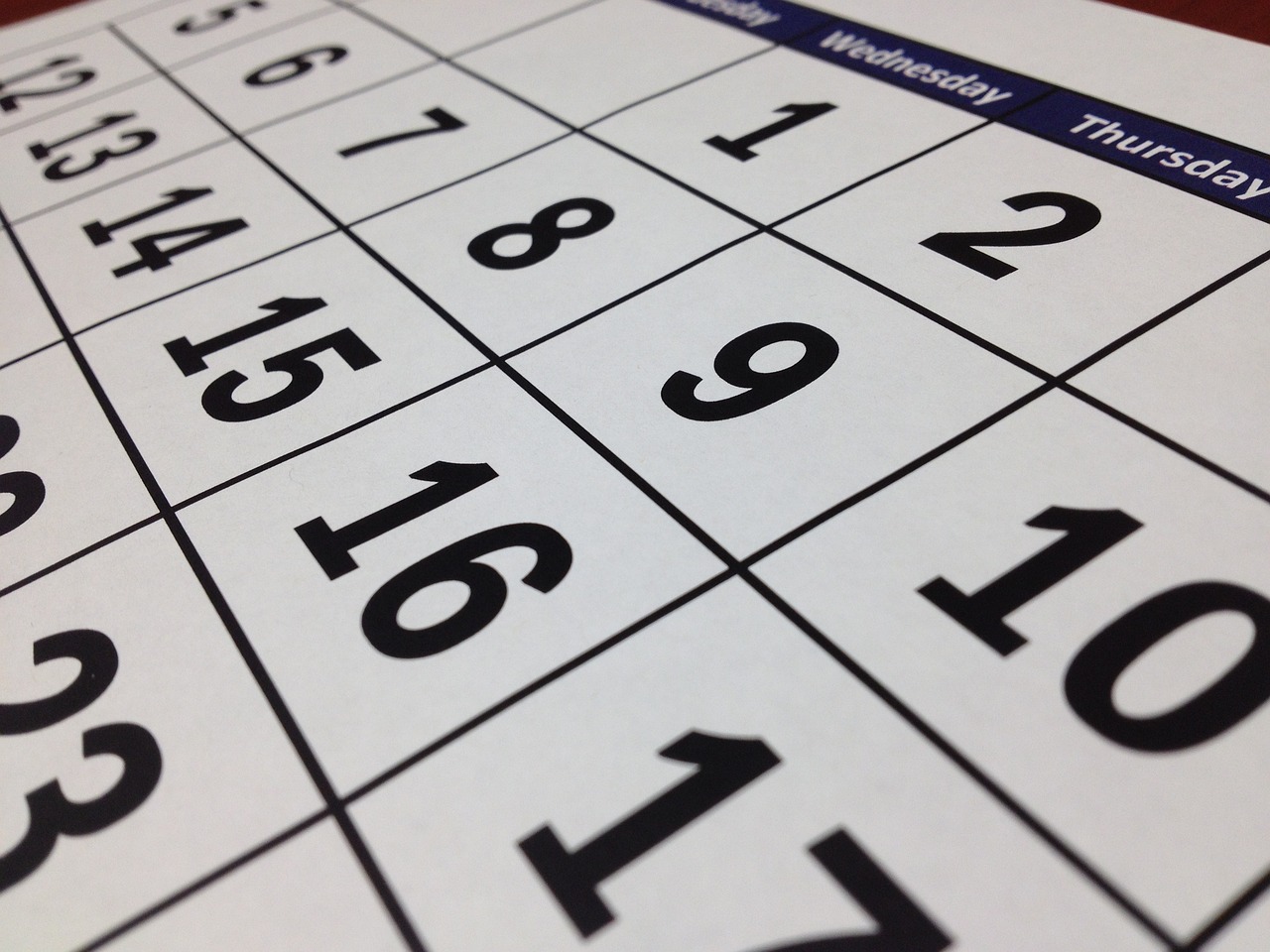 sideways angled photo of a calendar. White paper black numbers/dates. This image is by tigerlily713 from Pixabay
