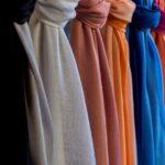colorful scarves lined up along a wall. Image by Nino Carè from Pixabay