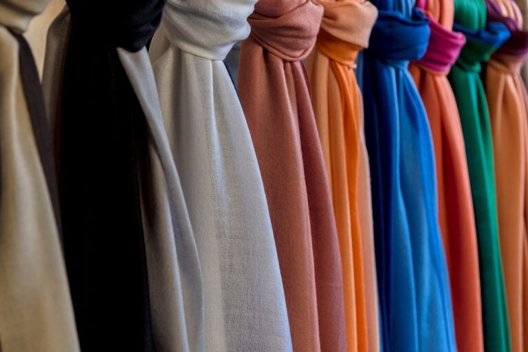 colorful scarves lined up along a wall. Image by Nino Carè from Pixabay