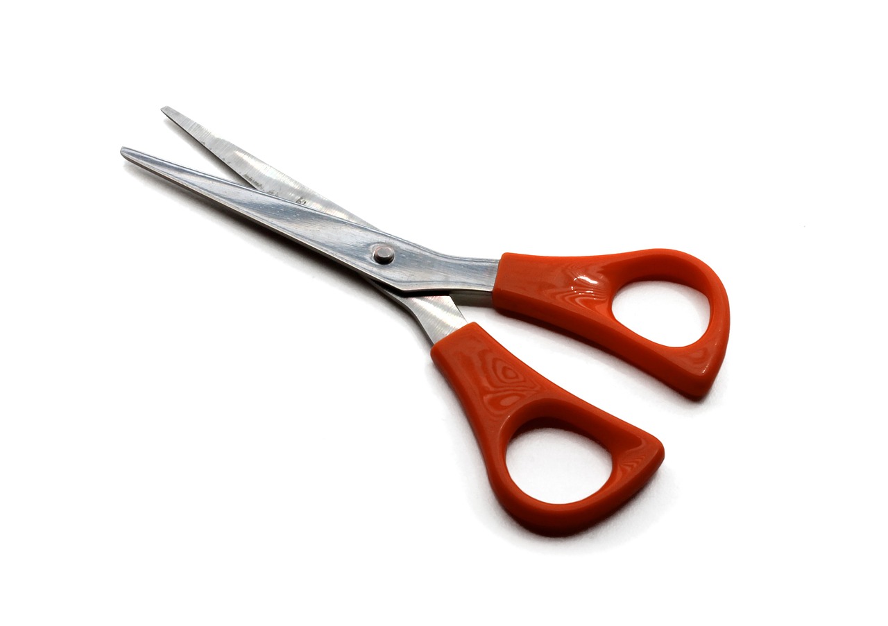 pair of red handled scissors set against a white background.