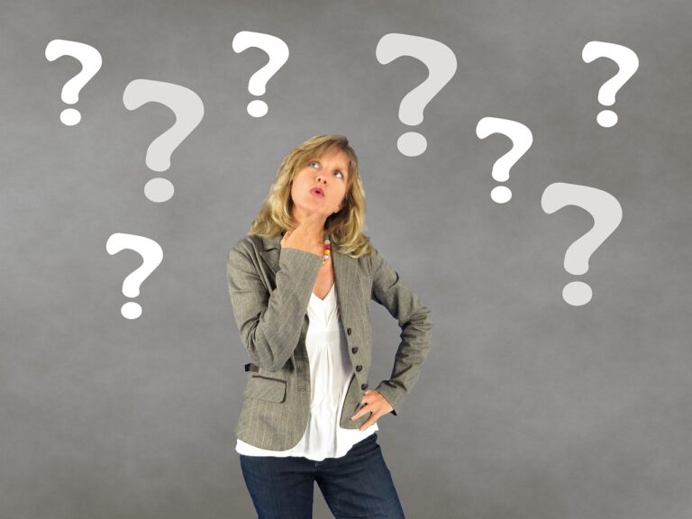 Photo of woman looking up, rubbing her chin, looking puzzled at the 8 white question marks above and around her head. Woman is wearing blue jeans, a white blouse and a grey blazer. Background is grey. Image by Sophie Janotta from Pixabay. https://pixabay.com/photos/woman-question-mark-person-decision-687560/