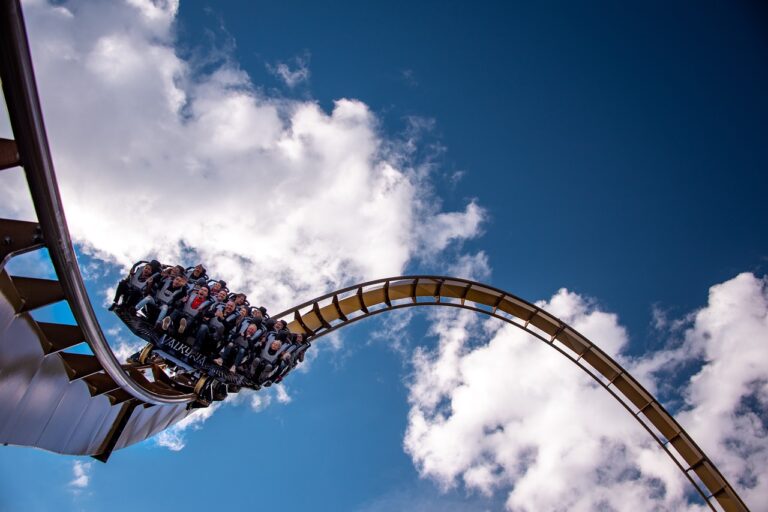 Blue sky, puffy white clouds, roller coaster with a car full of people. This photo is from Pasi Mämmelä from Pixabay Link: https://pixabay.com/photos/roller-coaster-liseberg-sweden-7255670/