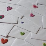Finding Your Community Through Podcasting backs of white envelopes with heart stickers of varying sizes and colors.
