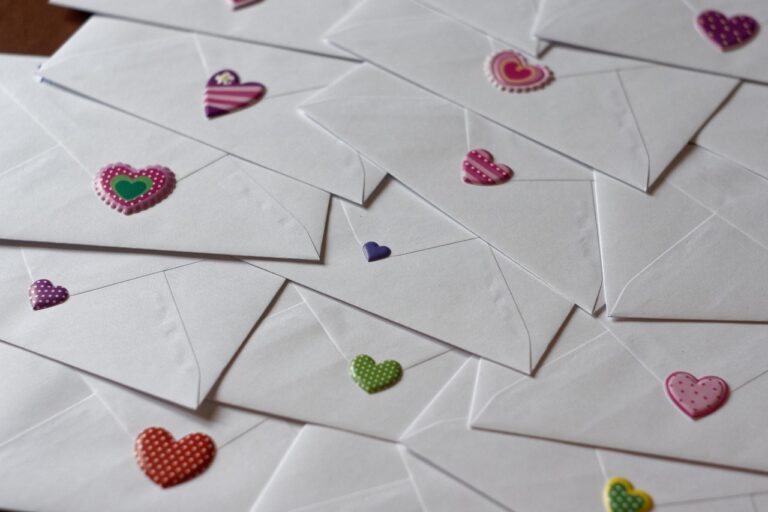 backs of white envelopes with heart stickers of varying sizes and colors.