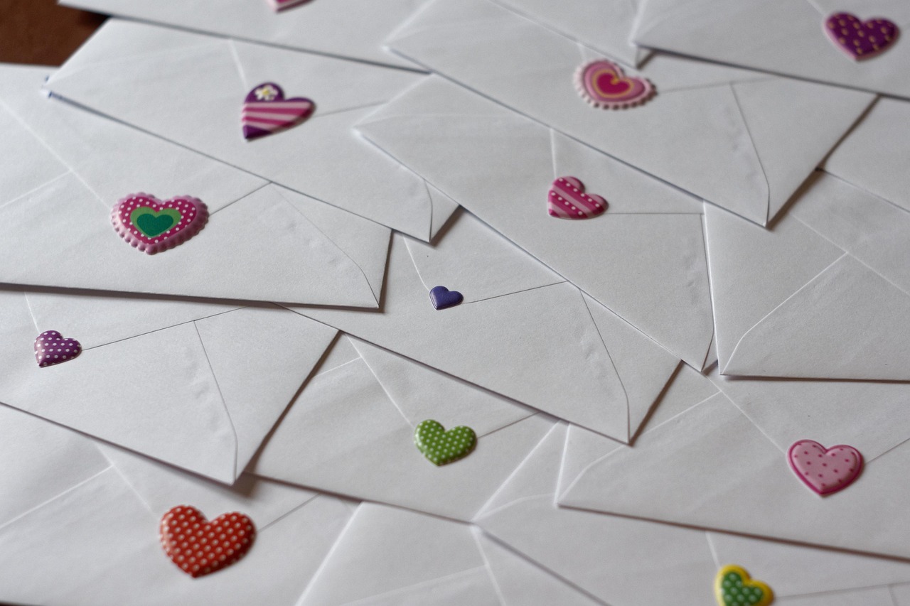 backs of white envelopes with heart stickers of varying sizes and colors.